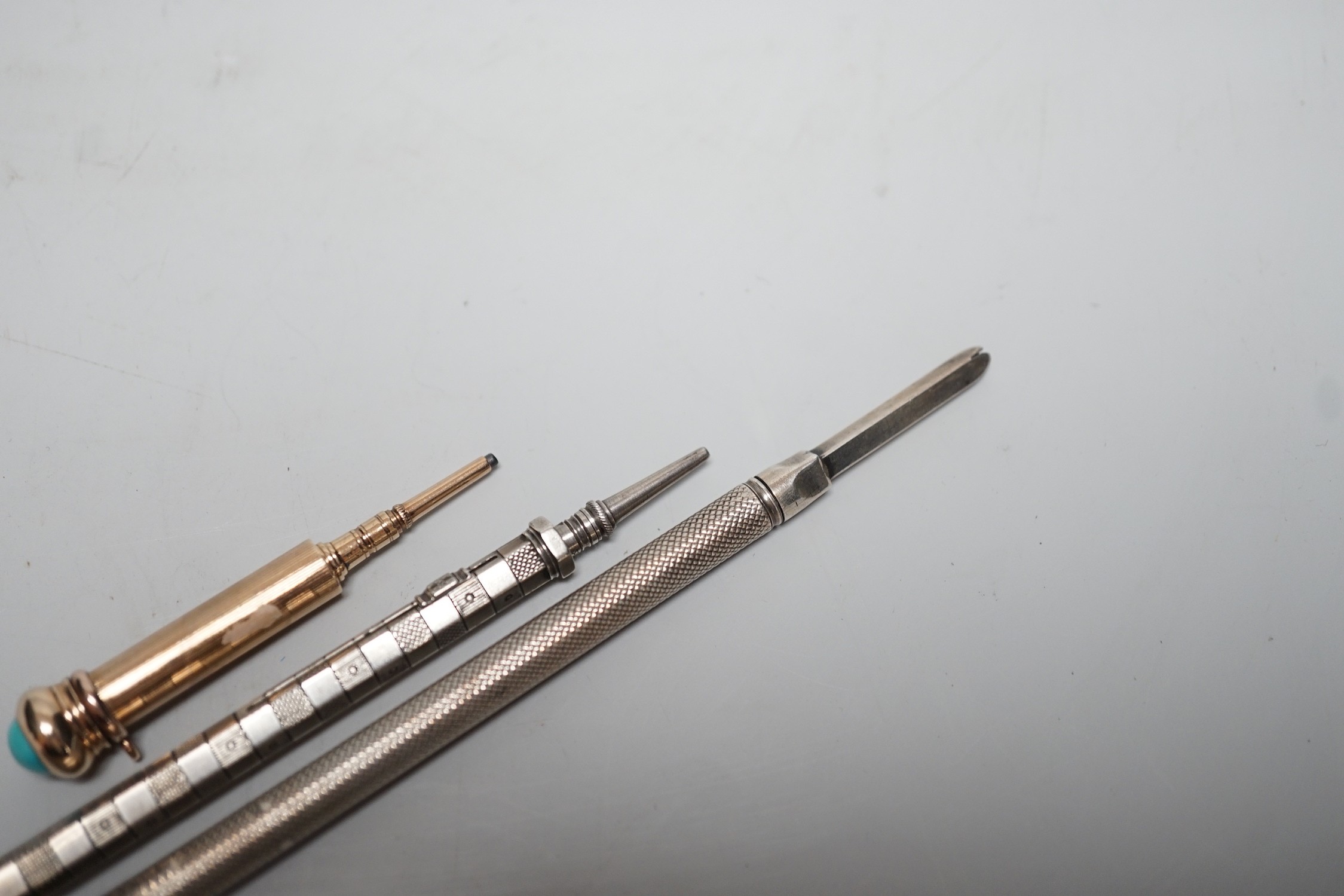 Two silver pencils and a turquoise set propelling pencil